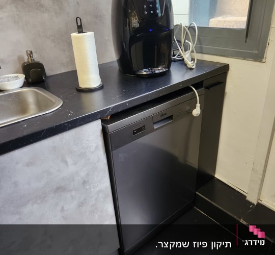 מטען חשמלי מחובר לשקע על השיש
